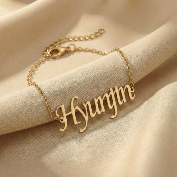 Custom gold name bracelet with 'Hyunjin' pendant on beige fabric